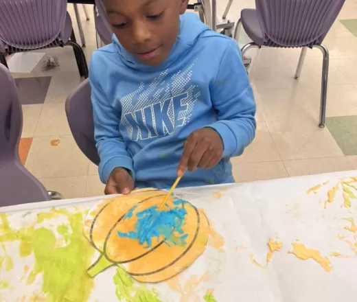 Boy painting pumpkin picture at the Y!